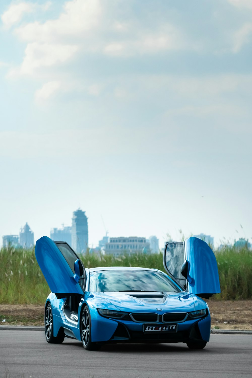 a blue sports car parked on the side of the road