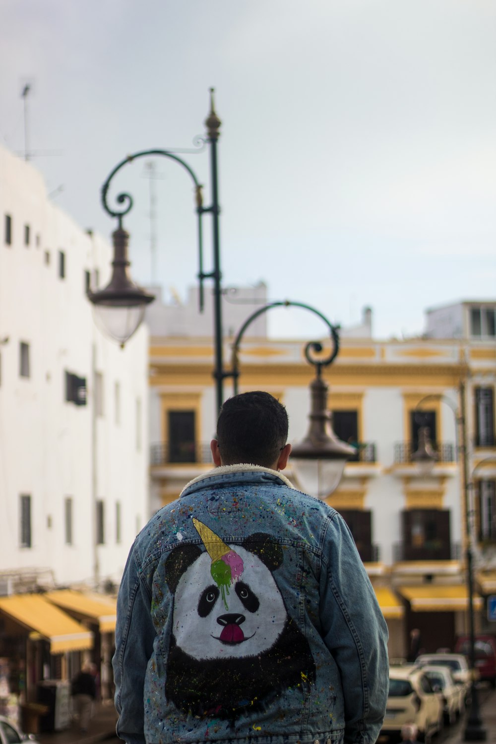 a man wearing a jacket with a panda face painted on it