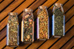 three glass jars filled with different types of herbs