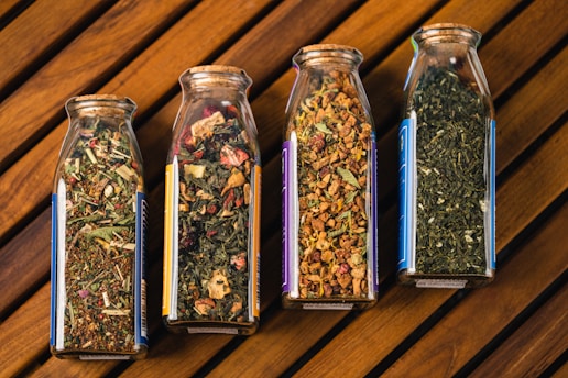 three glass jars filled with different types of herbs