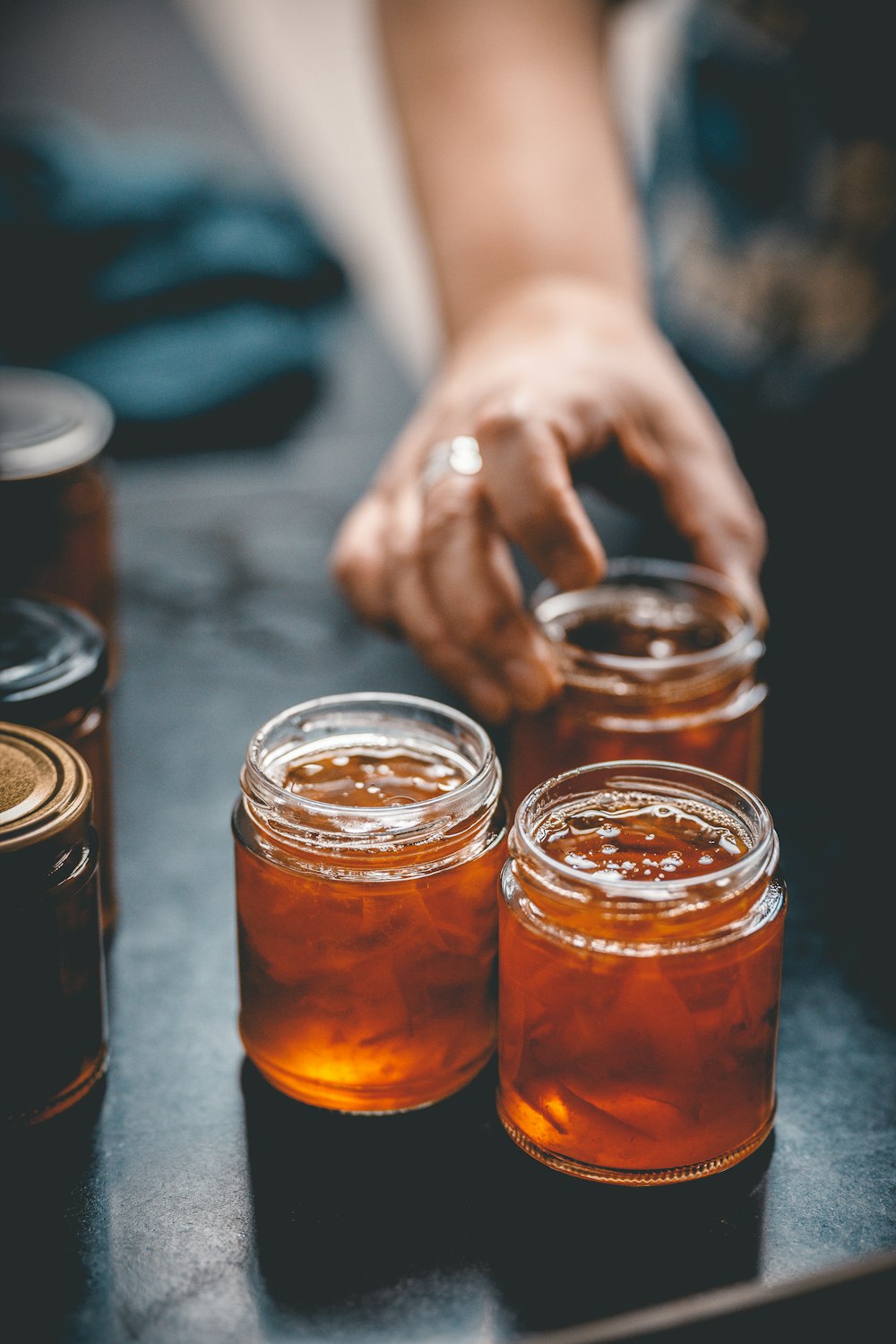 Tres frascos de miel se sientan sobre una mesa