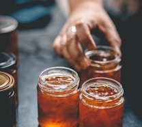 three jars of honey sit on a table