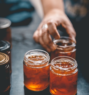 three jars of honey sit on a table
