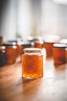 Colorful jars of traditional Turkish jams lined up on a sunlit kitchen shelf.