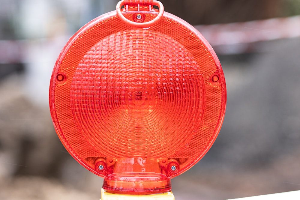 a red stop light sitting on top of a yellow pole