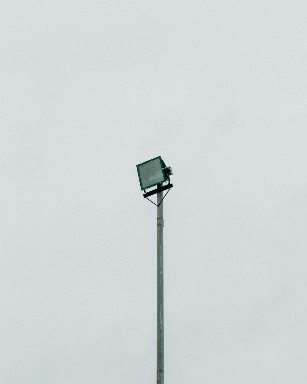 a street light with a green box on top of it