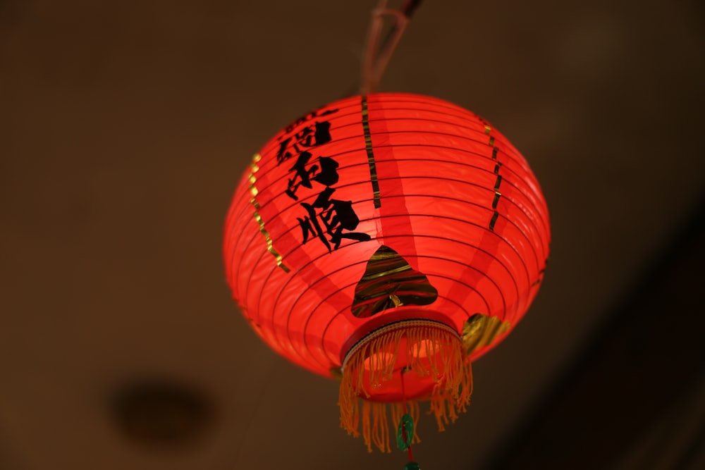 a red chinese lantern hanging from a ceiling