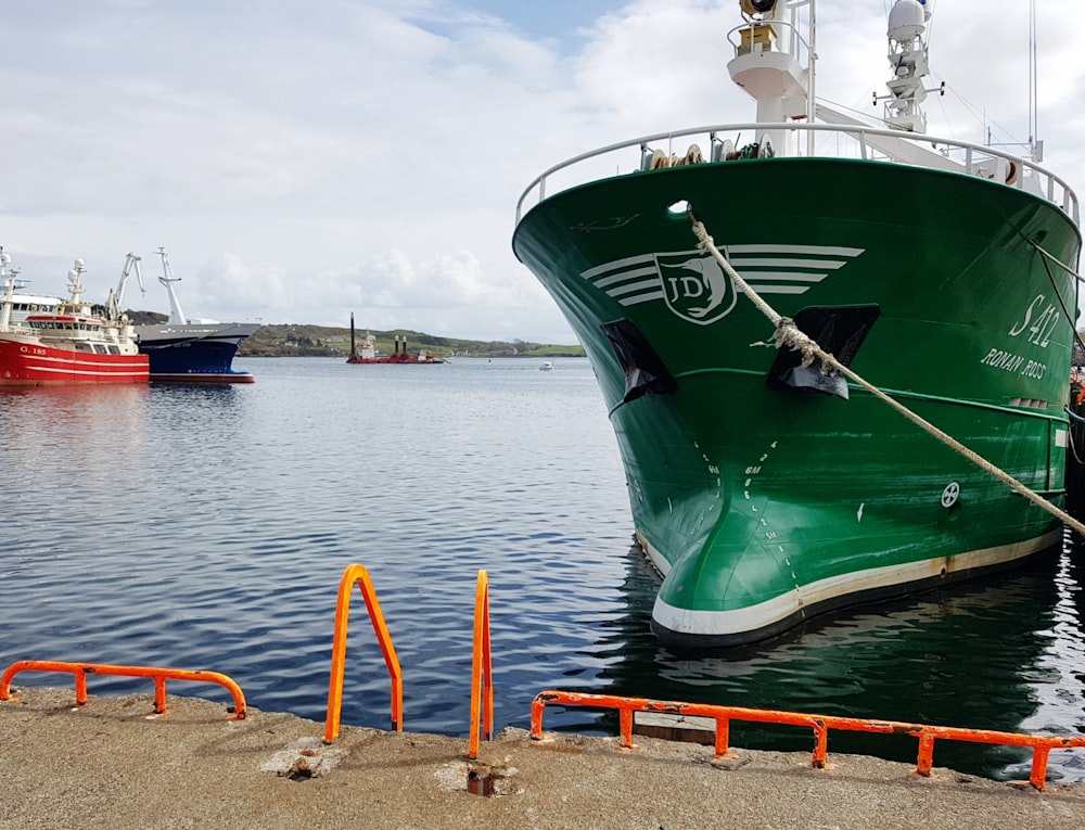 a large green boat docked at a dock