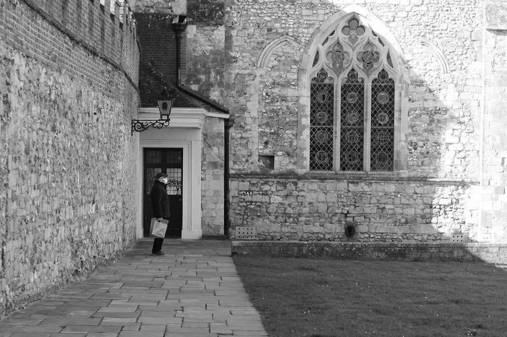 a black and white photo of a man entering a church