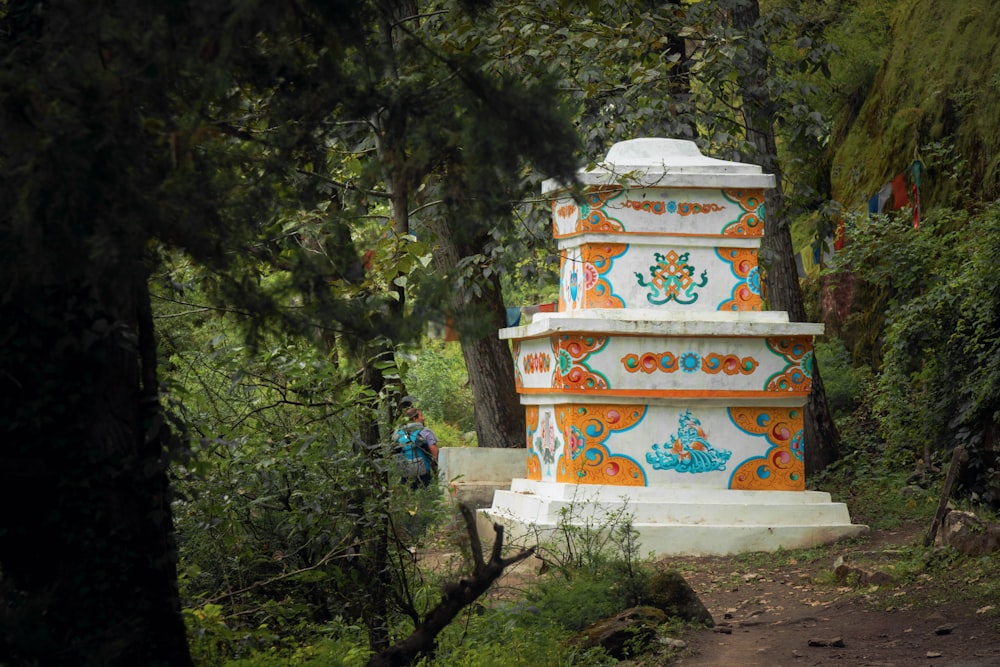 a colorfully painted tower in the middle of a forest