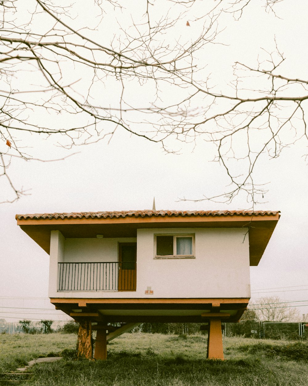 Una piccola casa seduta in cima a un campo verde lussureggiante