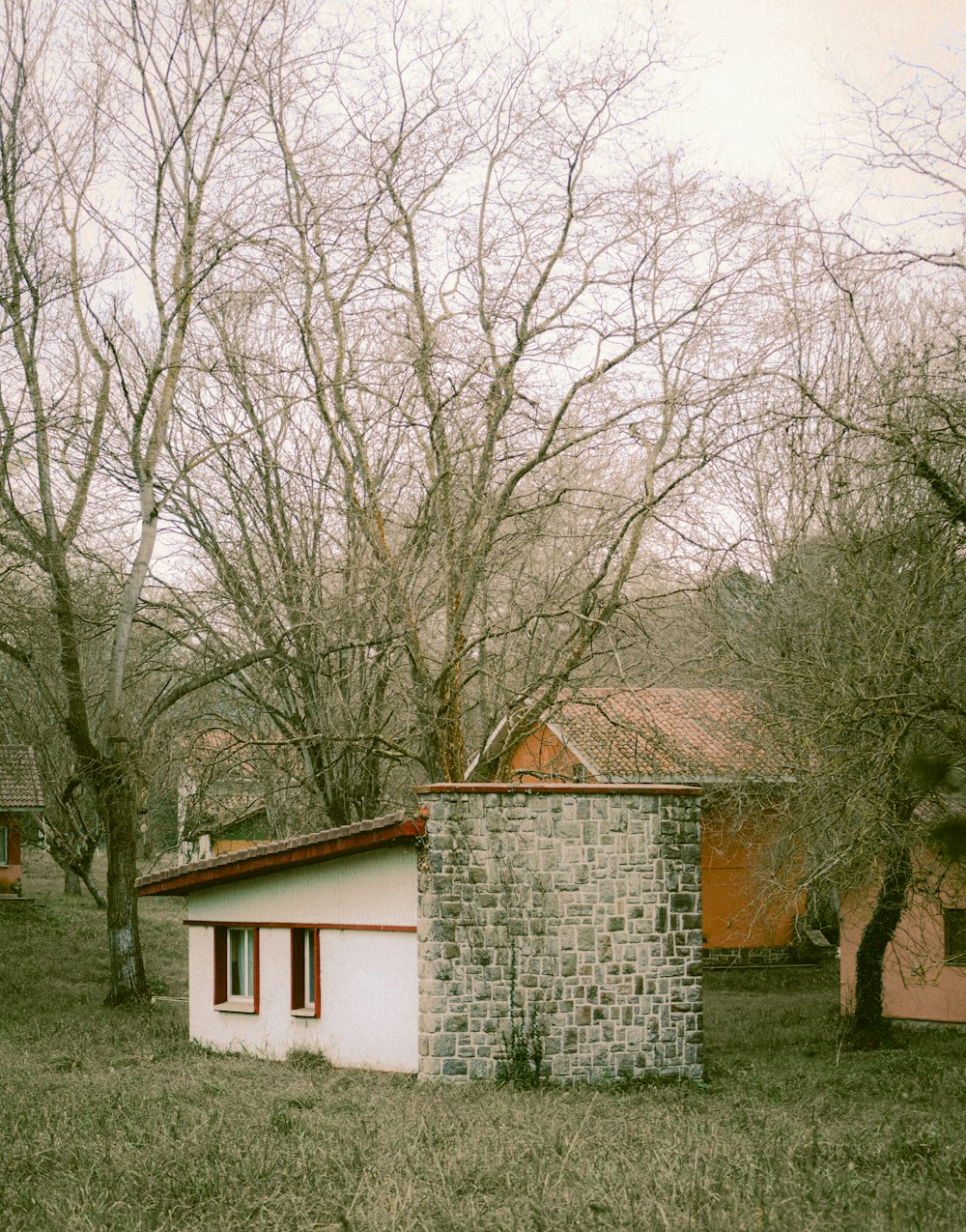 a small brick building sitting in the middle of a field