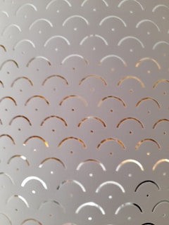 Metal surface engraved with a detailed geometric design reflecting light.