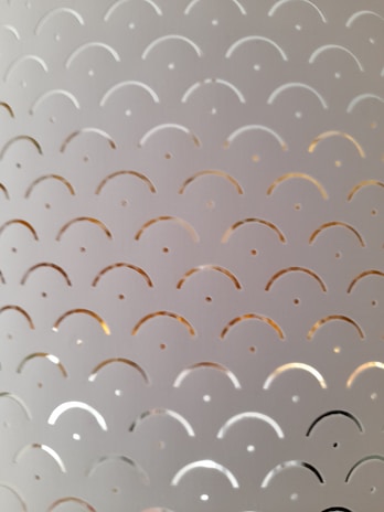Metal surface engraved with a detailed geometric design reflecting light.
