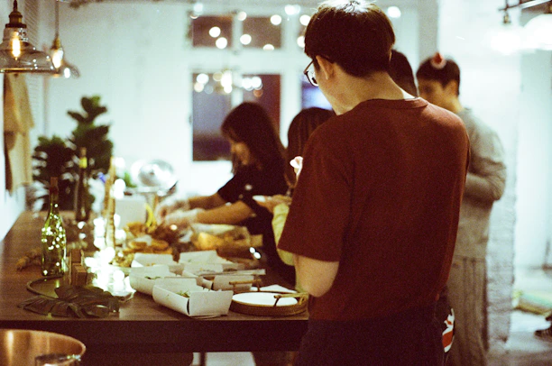 A cheerful group enjoying a variety of catered dishes around a cozy table.