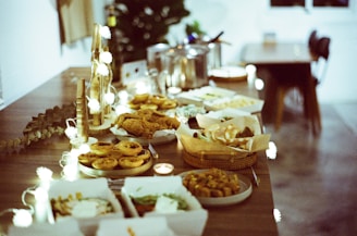 A comforting funeral reception table with warm, home-style dishes and soft lighting