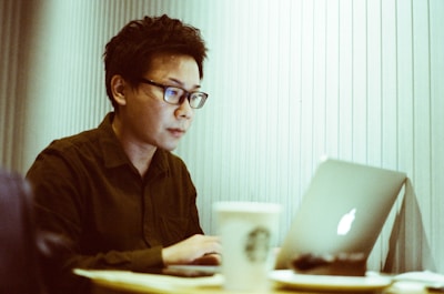 A digital nomad working on a laptop at an airport lounge with a coffee.