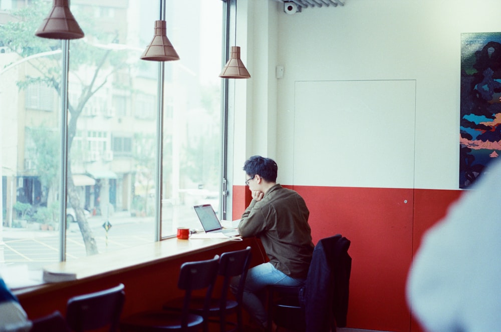 a man sitting at a table using a laptop computer