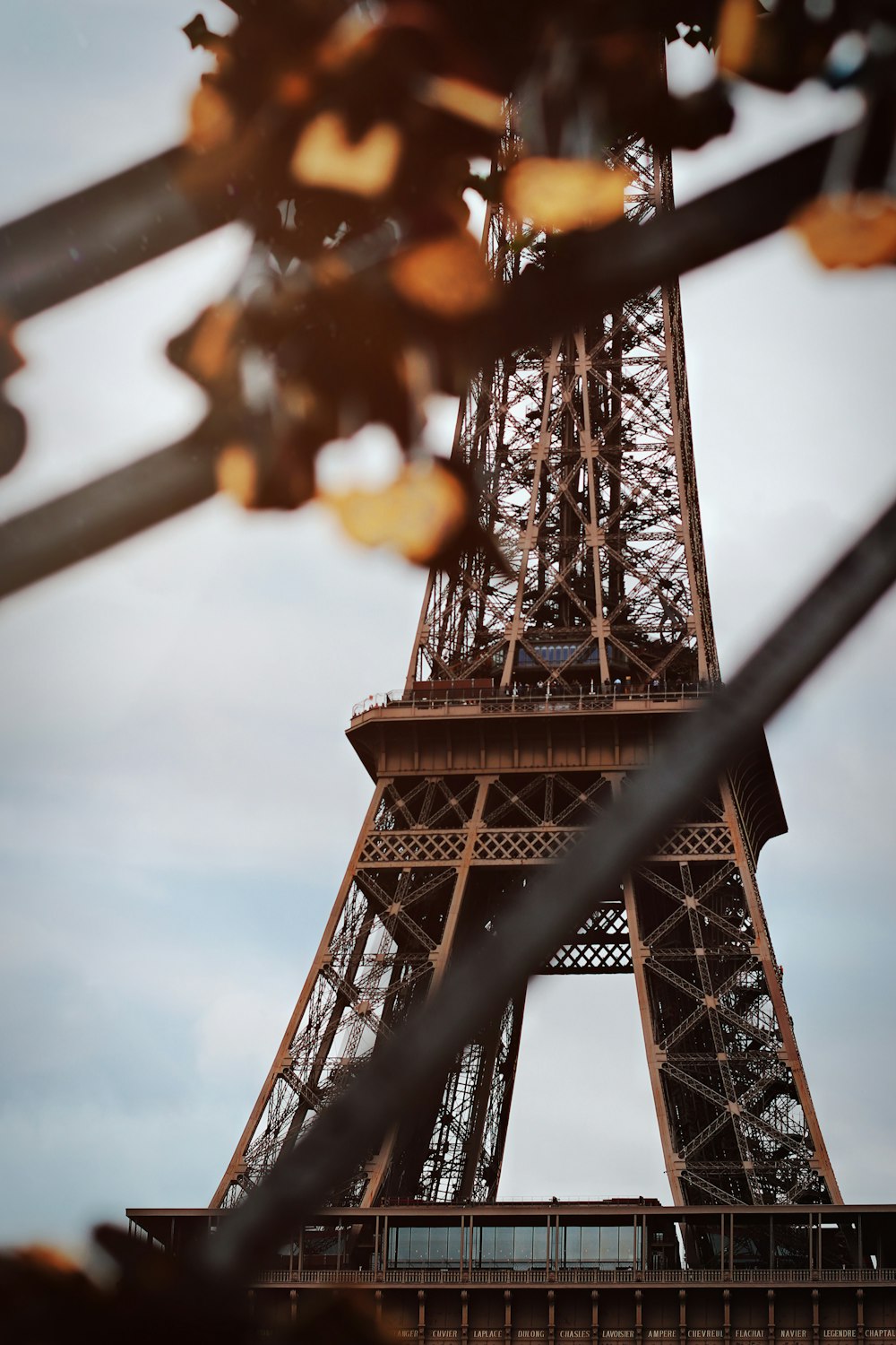 a view of the eiffel tower through a fence