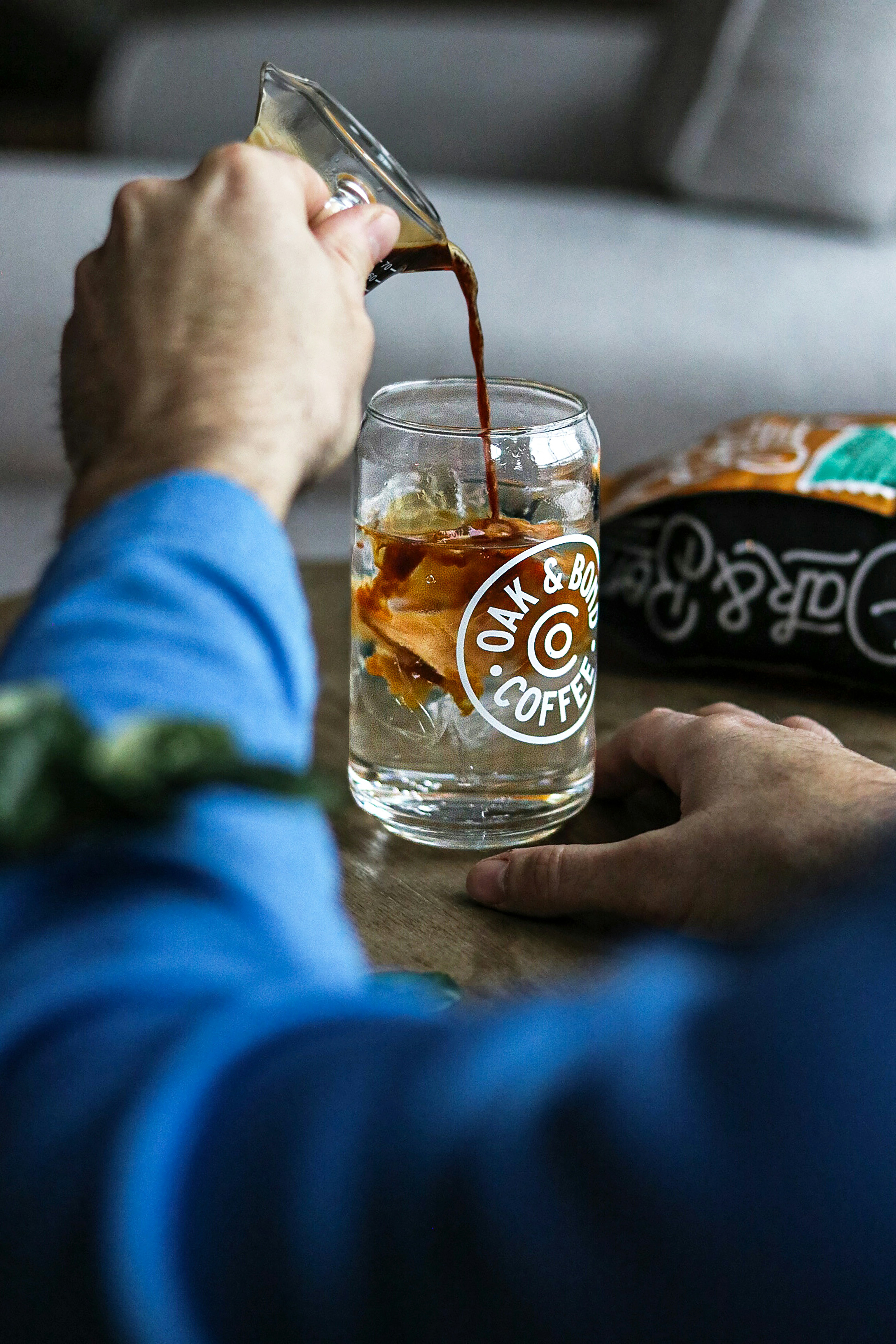 a person pouring a beverage into a glass