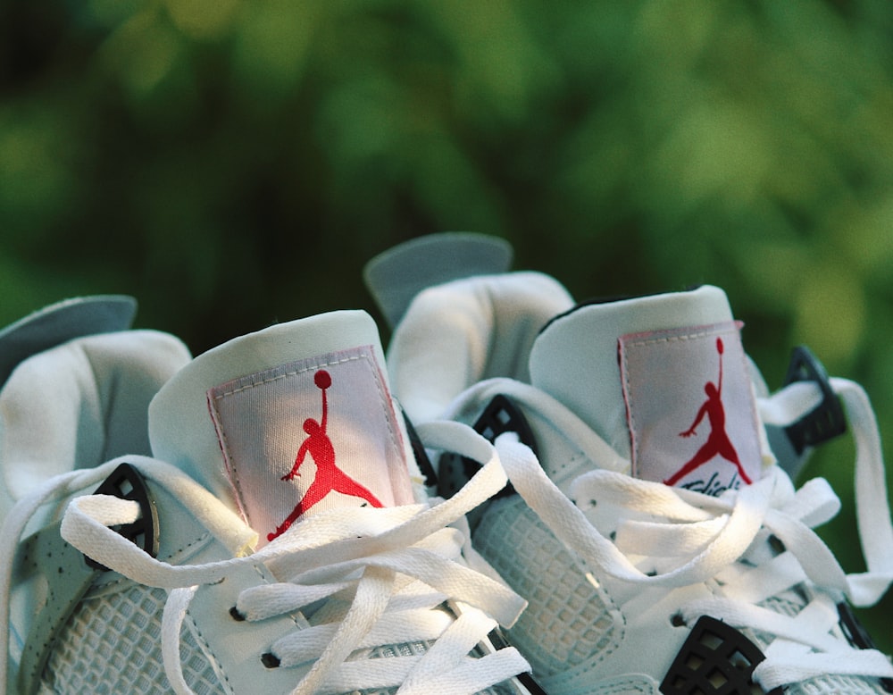 a pair of sneakers with a red and white logo on them