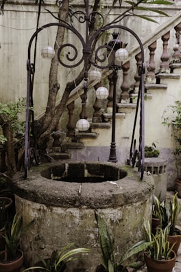 The village’s historic well surrounded by blooming marigolds and stone steps.