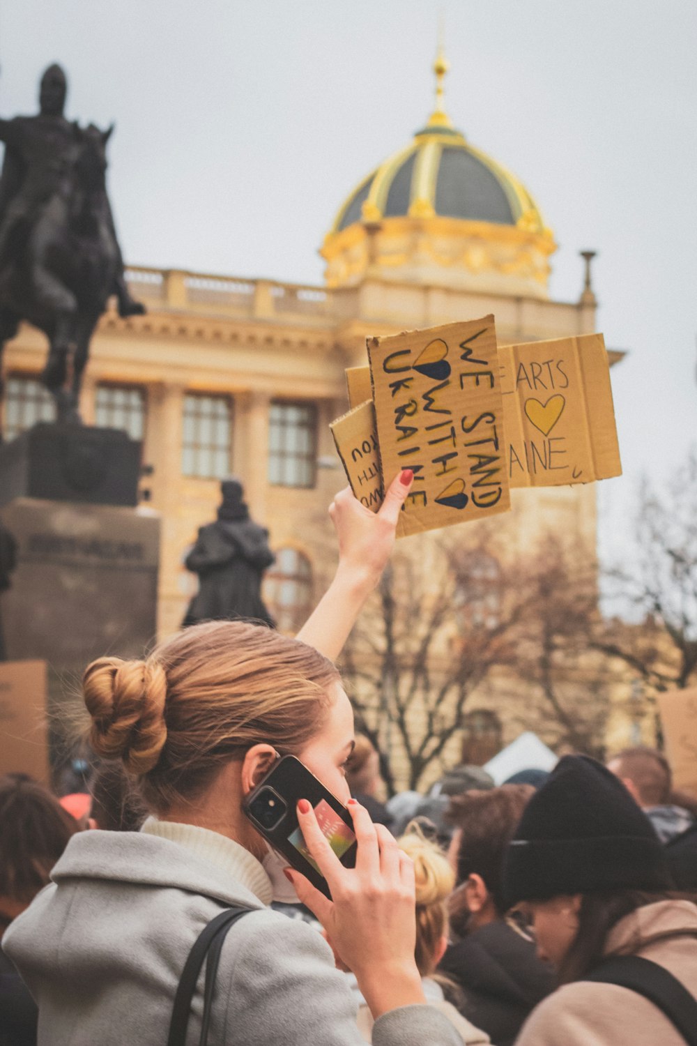 a woman holding up a sign in front of a building