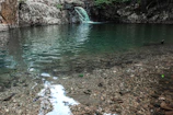 a body of water with a waterfall in the background