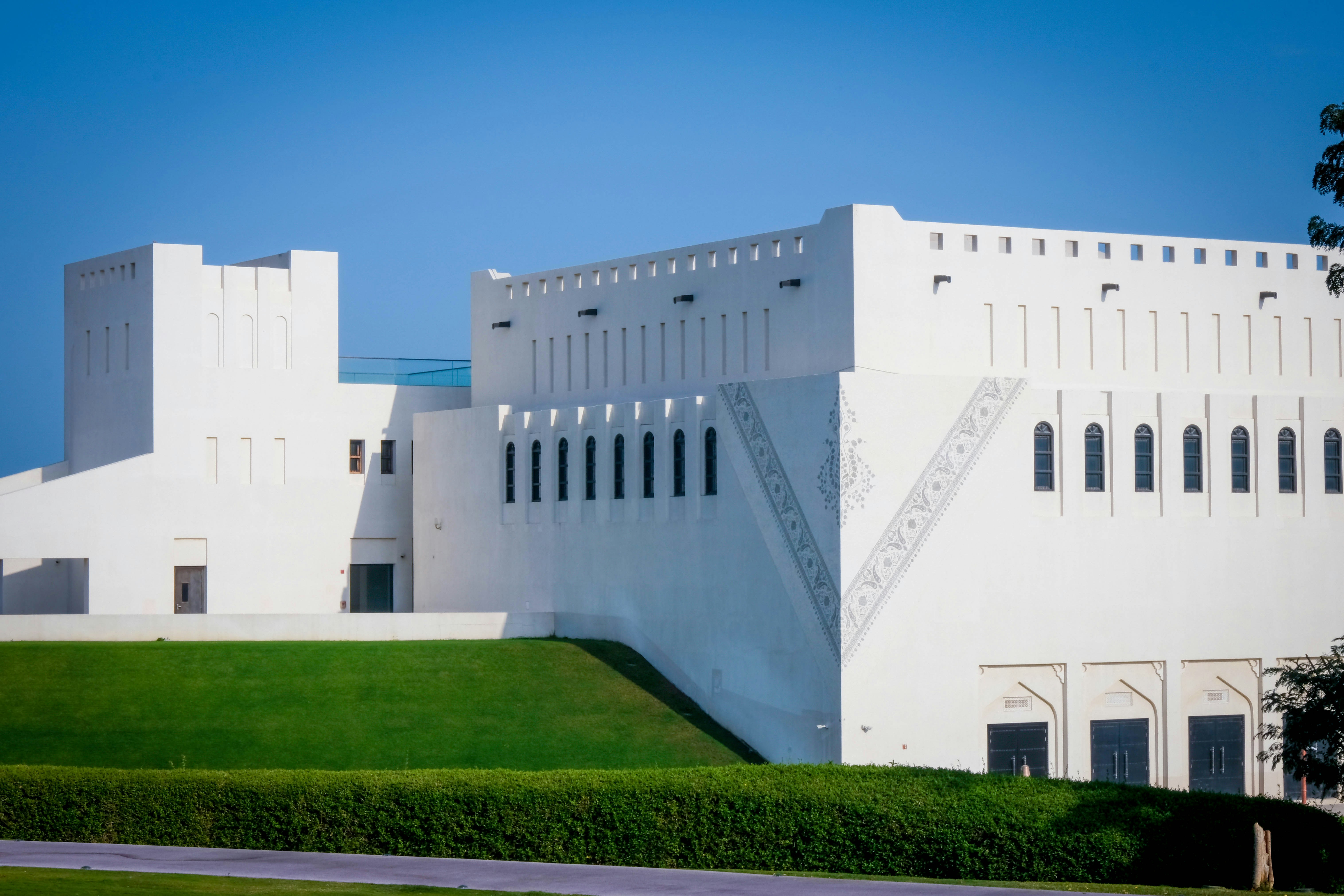 a large white building sitting on top of a lush green field