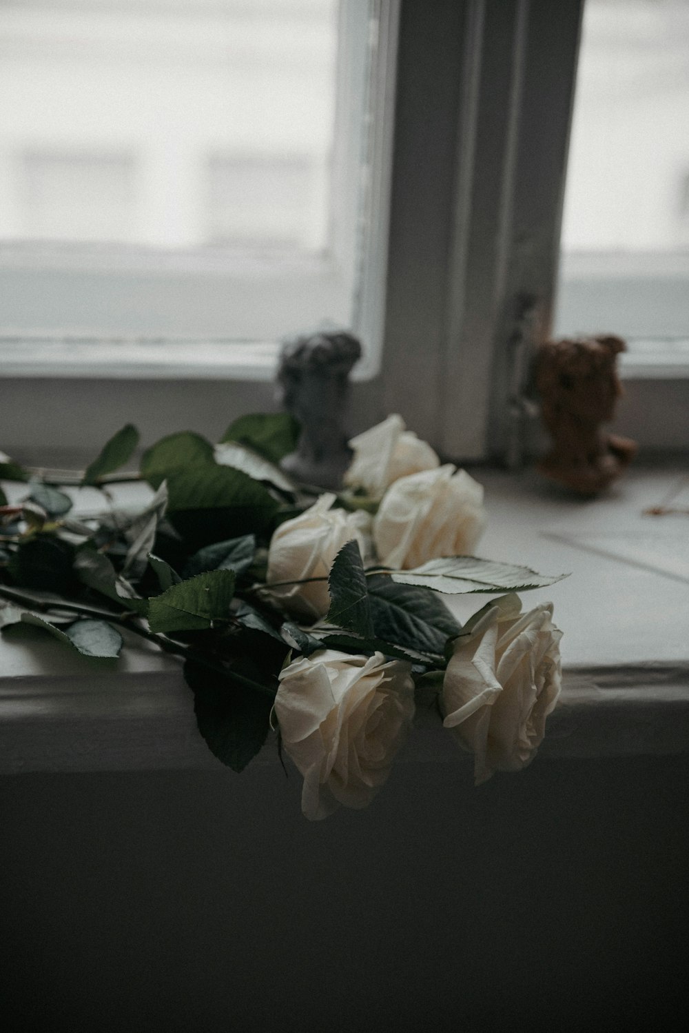 a bunch of white roses sitting on a window sill