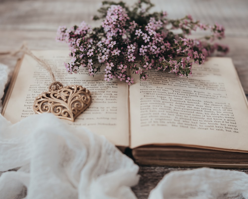 a book with a heart shaped ornament on top of it