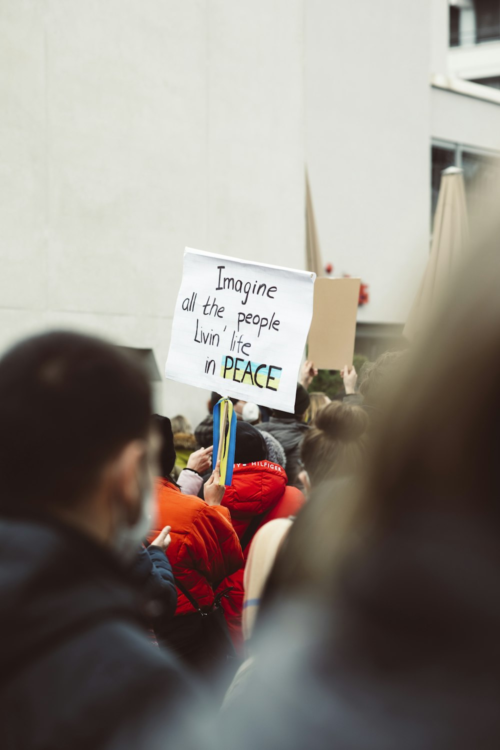 a person holding a sign that says imagine all the people living in peace