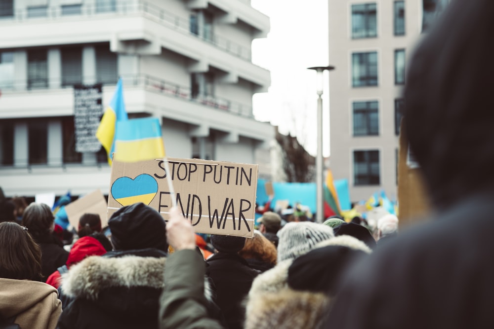 a crowd of people holding signs and flags