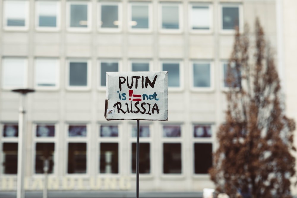 a protest sign in front of a building