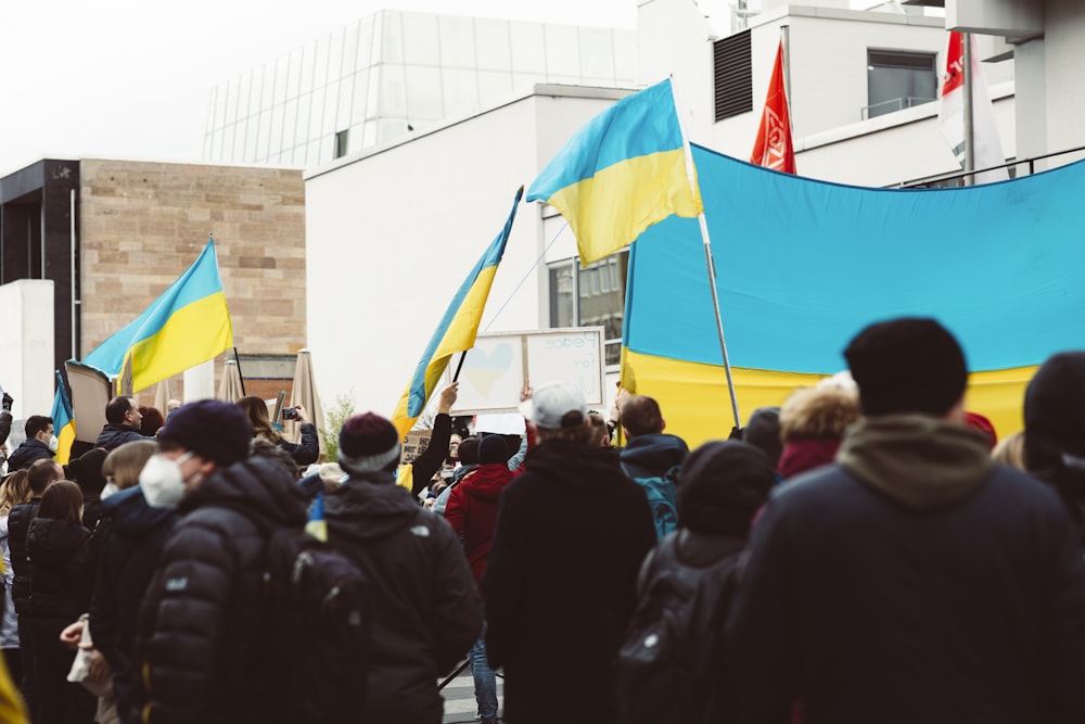 a group of people walking down a street holding flags