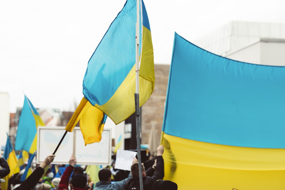 un groupe de personnes tenant des drapeaux et des pancartes