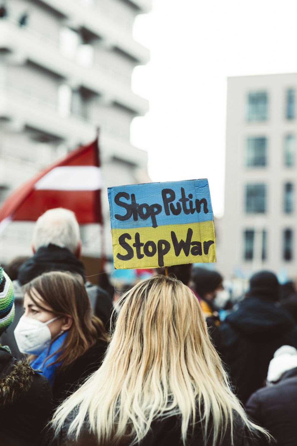 a group of people standing around each other holding signs