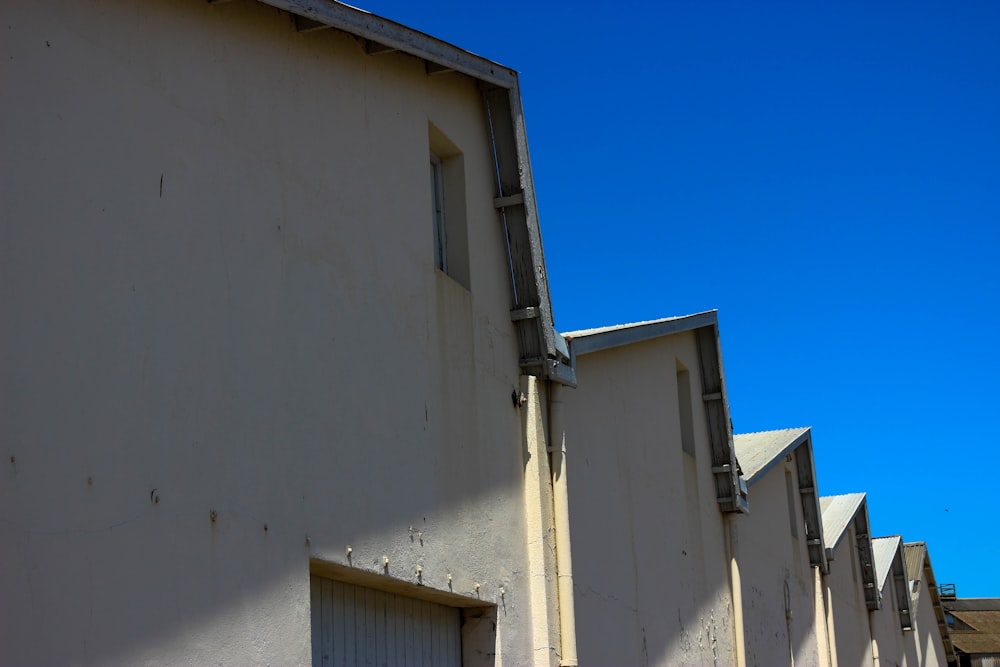 a row of white buildings with a blue sky in the background