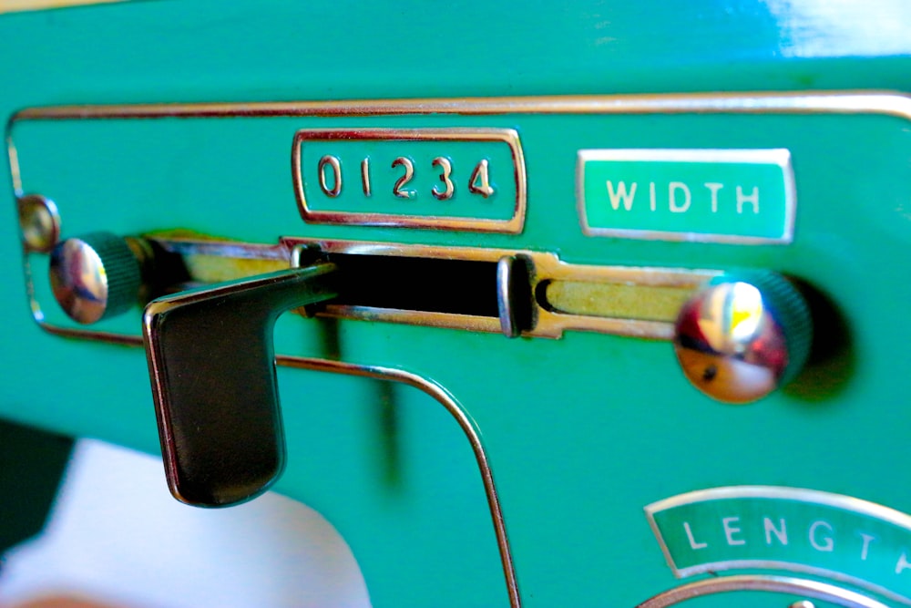 a close up of a green machine with a metal handle