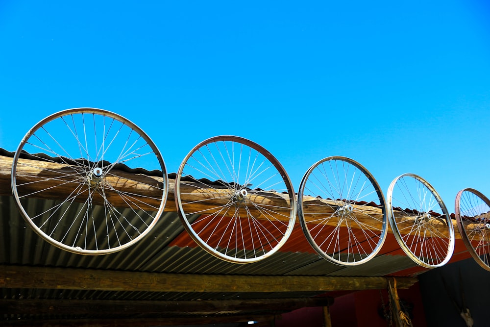a row of bicycle wheels sitting on top of a roof