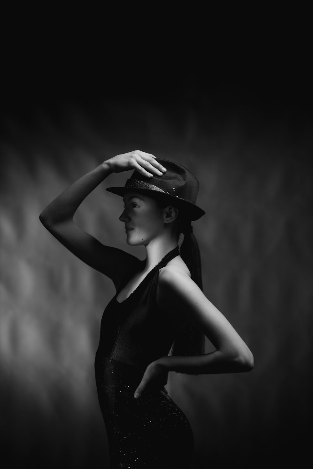 a black and white photo of a woman wearing a hat