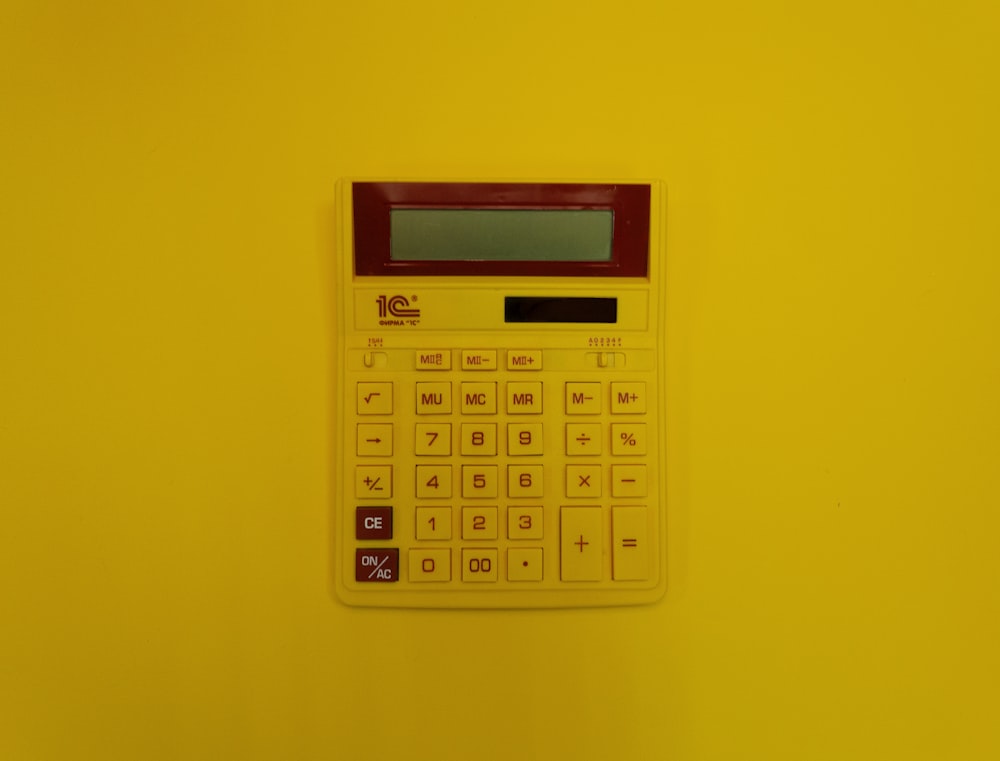 a calculator mounted on a yellow wall