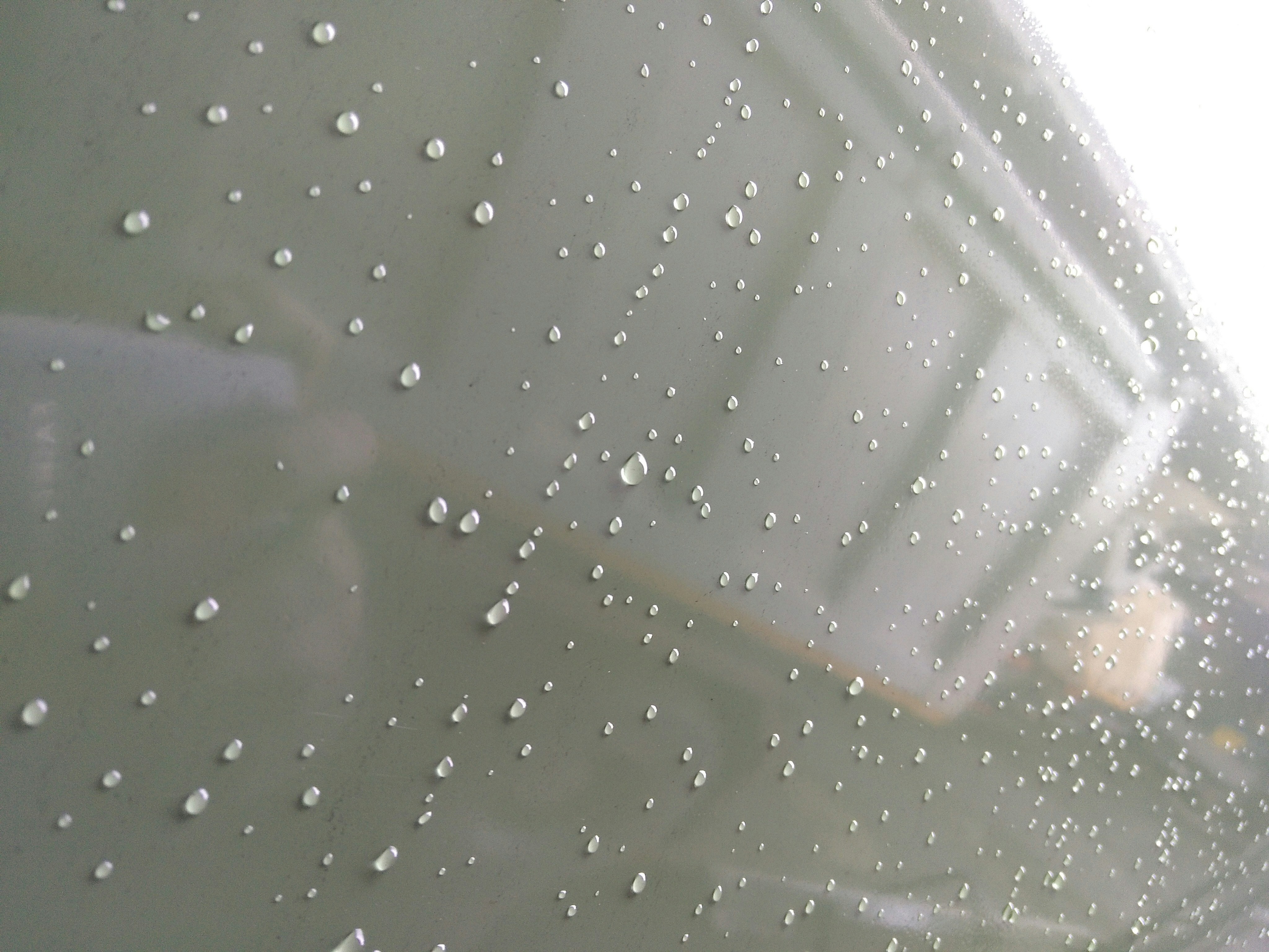 Duşakabin üzerindeki kireç lekelerini temizlemek için hazırlanan doğal içerikli sprey şişesi ve pırıl pırıl parlayan banyo camı.