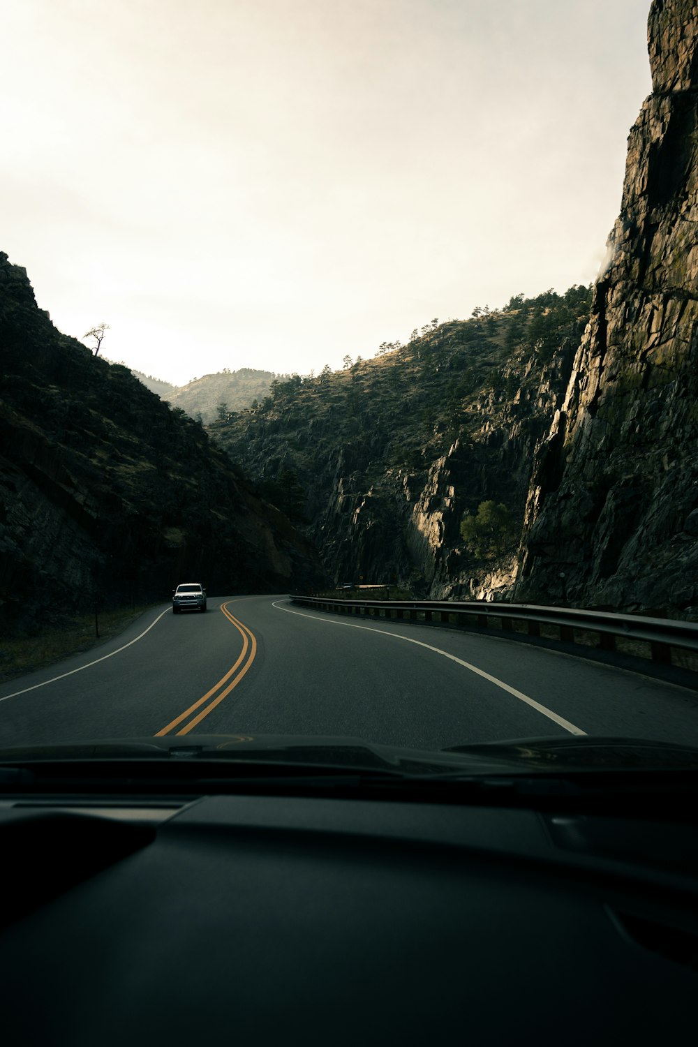 a car driving down a mountain road next to a cliff
