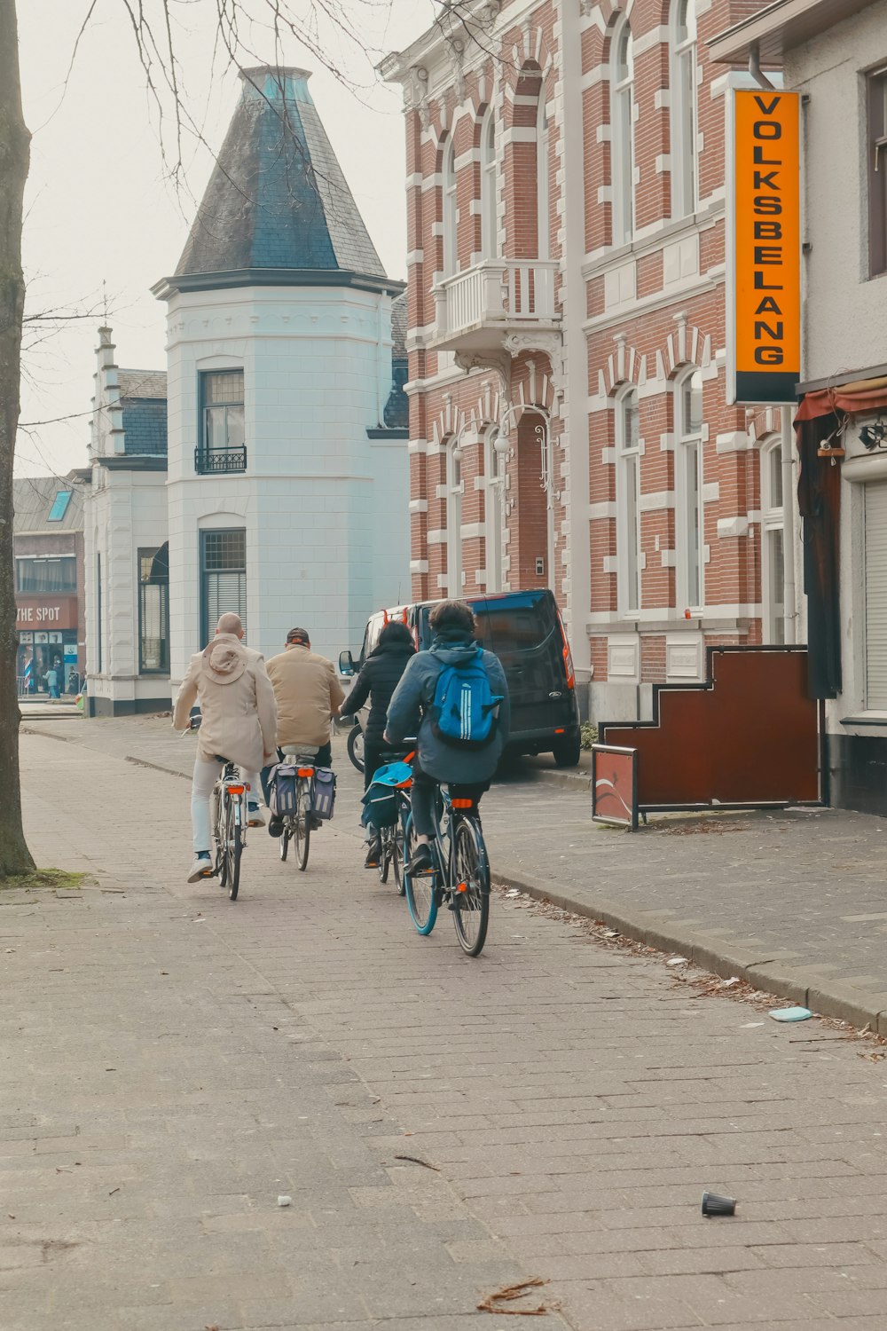 a group of people riding bikes down a street