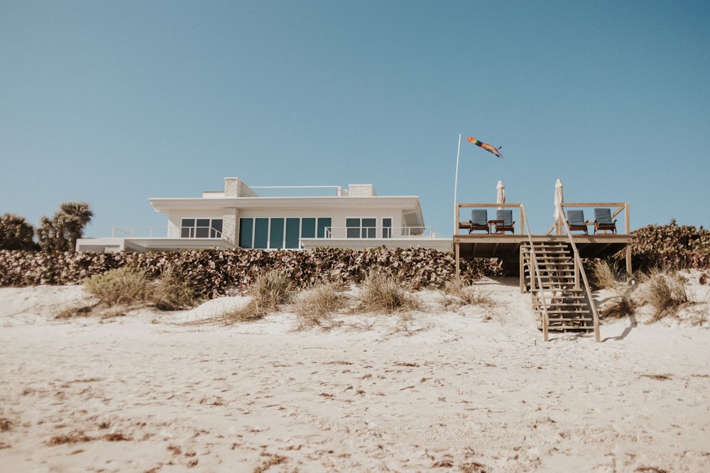 a house on the beach with a staircase leading to it