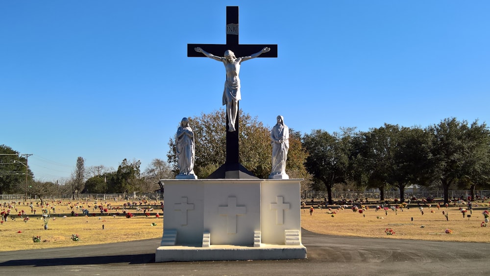 a statue of jesus on a cross in a cemetery