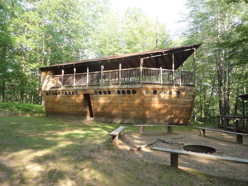 a large wooden boat sitting in the middle of a forest