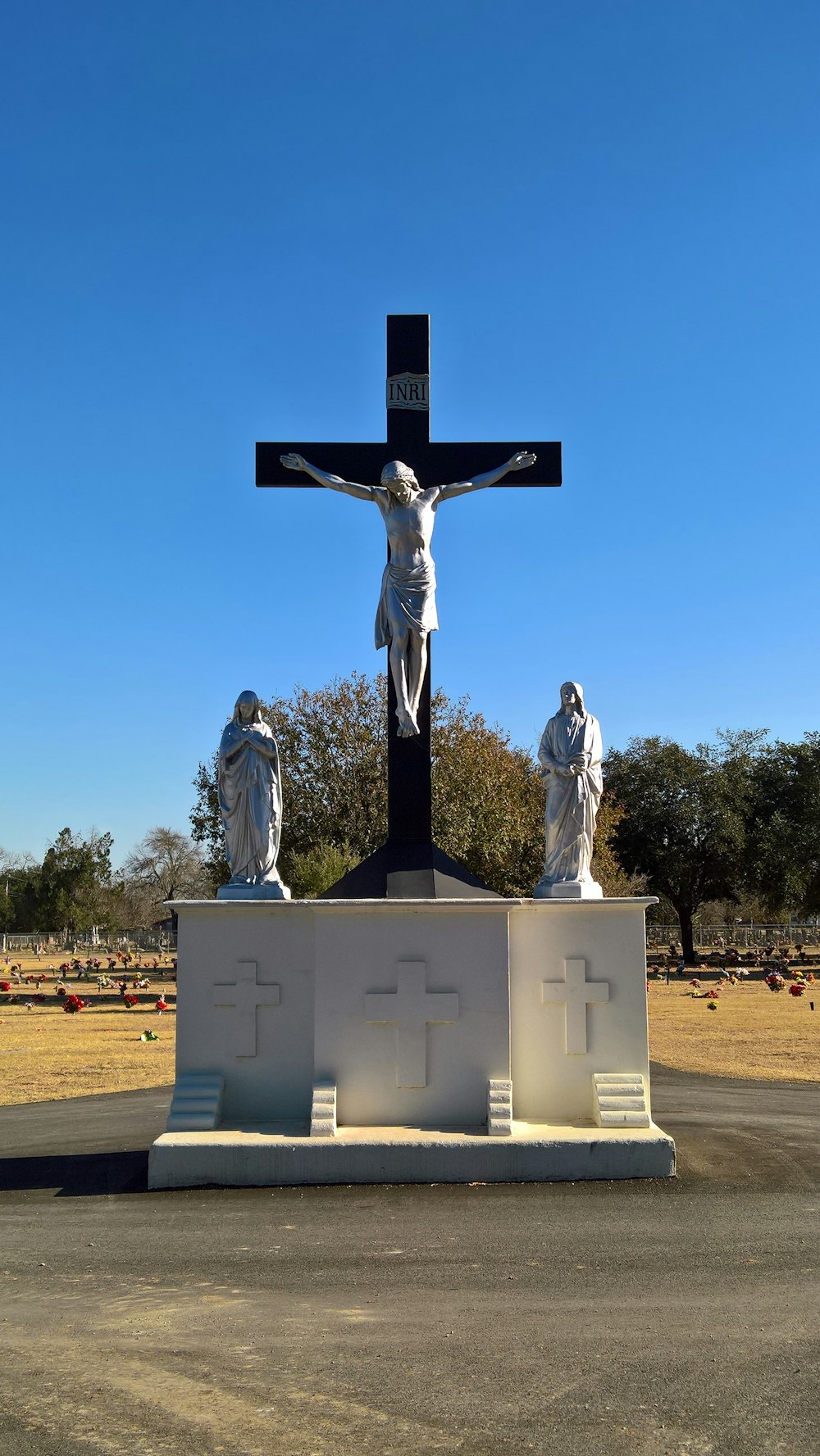 a cross with statues of jesus on it