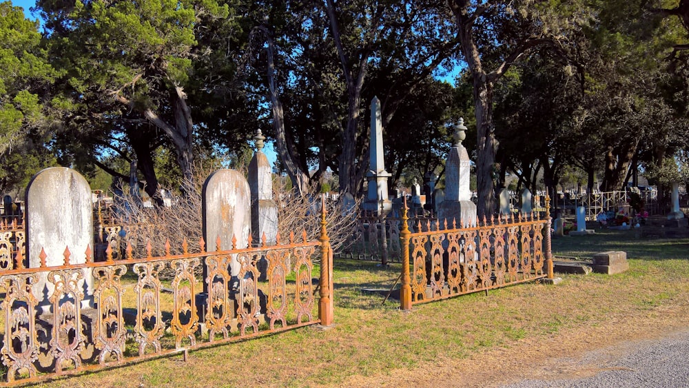 a cemetery with many headstones and trees in the background